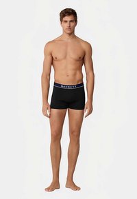 Crne bokserice s plavim pojasom na kojem piše "HACKETT." Bokserice su uskog kroja i izrađene od mekog, rastezljivog materijala.