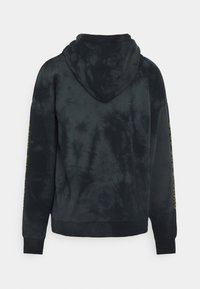 Černá mikina s tie-dye vzorem, s klokaní kapsou, žebrovanými manžetami a lemem. Obsahuje kapuci a jasně žlutý text podél rukávu.