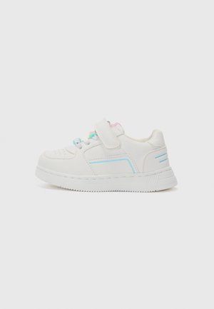 Witte sneakers voor kinderen met blauwe accenten, kleurrijke kralen op de veters en een enkele klittenbandsluiting op een effen achtergrond.