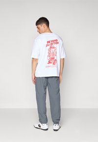 Umbro RELAXED TRACK PANT - Trainingsbroek - iron gate/red dahlia/brilliant white