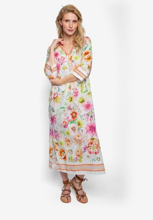Sukienka midi w kwiatowy wzór, wykonana z lekkiego materiału, z żywymi różowymi, pomarańczowymi i zielonymi nadrukami. Posiada rękawy do połowy przedramienia oraz dekolt w kształcie litery V.