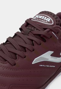 Κερασιού αθλητικό παπούτσι με λεία συνθετική επιφάνεια, έντονη δέσιμο, ασημί λογότυπο, λεπτομέρειες αερισμού και υφασμάτινες λεπτομέρειες.