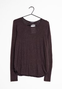 Haut à manches longues et col rond en tissu marron foncé, doté d'une coupe décontractée et d'un ourlet légèrement incurvé. Étiquette visible au niveau du col.