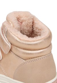 Svetloružová semišová členková obuv s kovovými detailmi, mäkkou vnútornou podšívkou a nastaviteľným zapínaním na remienok. Zaoblená špička a polstrovaný golier.