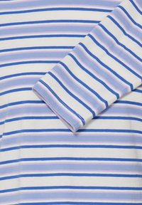 Chemise à rayures avec des couleurs alternées de bleu, bleu clair et lavande sur un fond blanc. Manches courtes avec une texture douce en coton.