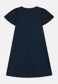 Tengerészkék ruha rövid puffos ujjakkal, melyen kis gyöngyszerű díszítések találhatók, amelyek pöttyös mintázatban vannak elhelyezve az anyagon.