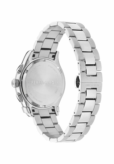 Sidabrinės spalvos nerūdijančio plieno Ferragamo laikrodžio apyrankė ir nugarėlė su sagtimi, vainikėliu ir dviem šoniniais mygtukais.