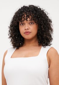 Top blanco sin mangas con escote cuadrado, textura suave y diseño minimalista, que presenta una tela suave y sin adornos.