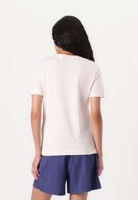 Lichtroze, kortom mouw t-shirt gemaakt van zachte stof, ronde halslijn en een relaxte pasvorm. Gecombineerd met gestructureerde, donkerblauwe shorts.