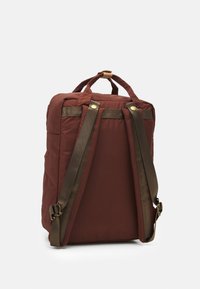 Brūna poliestera mugursoma ar mīkstu struktūru, brūnām siksnām un zelta aksesuāriem. Iespējo augšējo rokturi un logo detaļas aizmugurē.