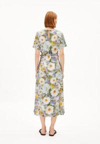 Midi-Kleid mit floralen Mustern aus leichtem Stoff. Hat kurze Ärmel, einen gebundenen Taillengurt und eine Schlitzöffnung am Rücken. In Grün- und Weißtönen.