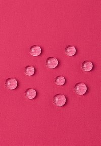 Klaren, runden Wassertropfen auf einer leuchtend pinken strukturierten Oberfläche, die in der Größe variieren, mit ausgeprägten Reflexionen und einer glatten Erscheinung.