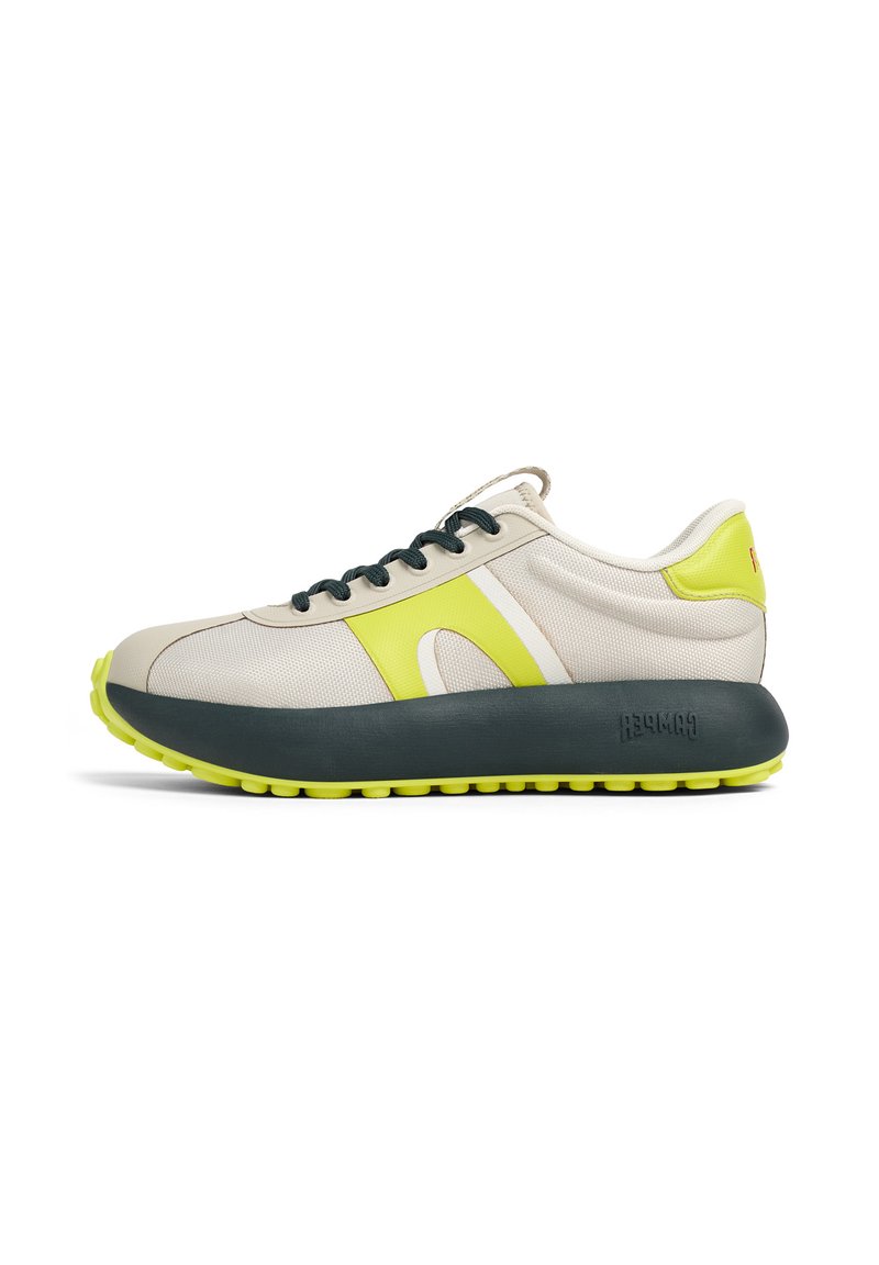 Sneaker con lacci in mesh beige e giallo con suola grigio scuro. Presenta lacci verdi e dettagli di accento sul lato e sul tallone.