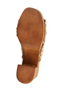 Κάτω όψη ενός σανδαλιού με σόλα από ξύλο σε καφέ απόχρωση, με τακούνι τύπου block και μεταλλικά καρφιά κατά μήκος των πλευρών.