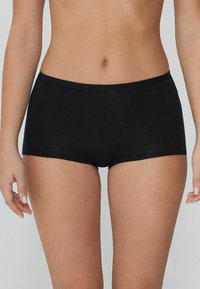 Pantalones cortos de algodón negro con una textura suave, diseño de cintura baja y una sencilla banda elástica.