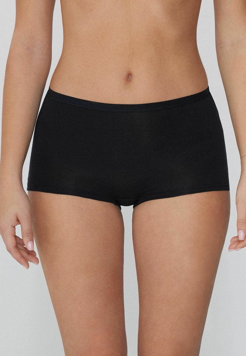 Pantalones cortos de algodón negro con una textura suave, diseño de cintura baja y una sencilla banda elástica.