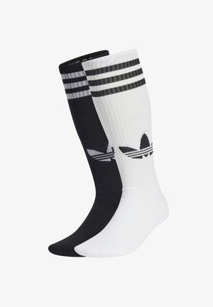 Two pairs of knee-length socks, one black and one white. Each features three horizontal stripes at the top and an Adidas logo.