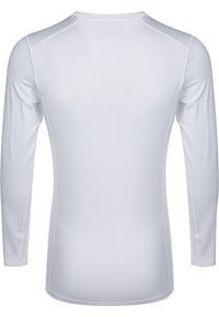 Chemise ajustée à manches longues en blanc, fabriquée en tissu léger et lisse, avec des coutures d'épaule raglan et un col arrondi.