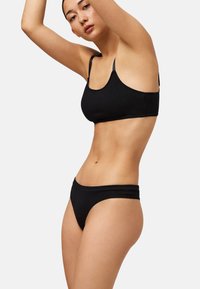 Conjunto de sujetador y bragas negras, con tela suave, diseño ajustado y delicado borde festoneado en los bordes.
