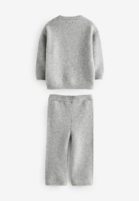 Grijze gebreide trui en bijpassende broek gemaakt van zacht, textuurstof. De trui heeft een ronde halslijn en geribde manchetten en onderrand.