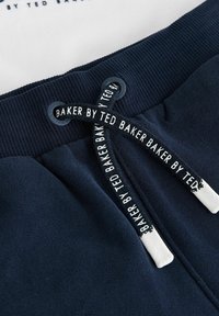 Námořnické modré bavlněné tepláky s žebrovaným pasem. Černobílá šňůrka s textem "BAKER BY TED BAKER". Měkčená textura, žádné viditelné vzory.