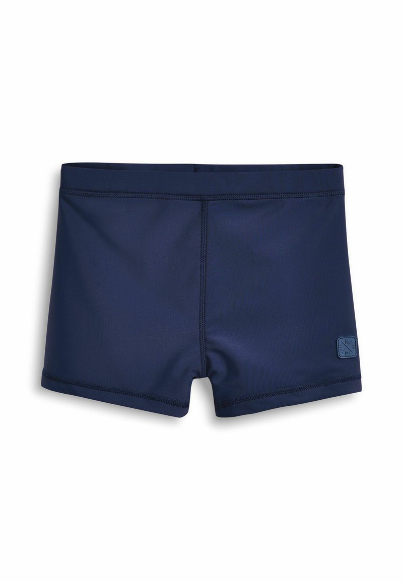 Mornarskoplave kupaće gaće izrađene od rastezljivog materijala, s ravnim šavovima i teksturiranom oznakom branda sa strane.