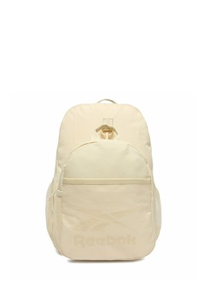 Beżowy plecak Reebok z przednią kieszenią na zamek, bocznymi kieszeniami z siateczki, górnym uchwytem oraz logo na przodzie na białym tle.