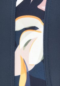 Tissu de maillot de bain avec une bordure marine et un motif floral abstrait dans des couleurs pastel, offrant une texture lisse et des détails de couture visibles.