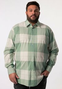 Camisa a cuadros verde y blanca con mangas largas, cierre de botones en el frente y un cuello clásico. Presenta una tela de algodón ligera y un corte holgado.