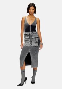 Denim dress with a zip front, deep V neckline, ribbed texture, and two large flap pockets. Gray with black accents and split hem.