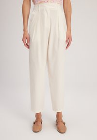 Pantaloni bianchi a vita alta con pieghe, realizzati in tessuto leggero. Presentano una chiusura con bottone frontale e gambe affusolate.