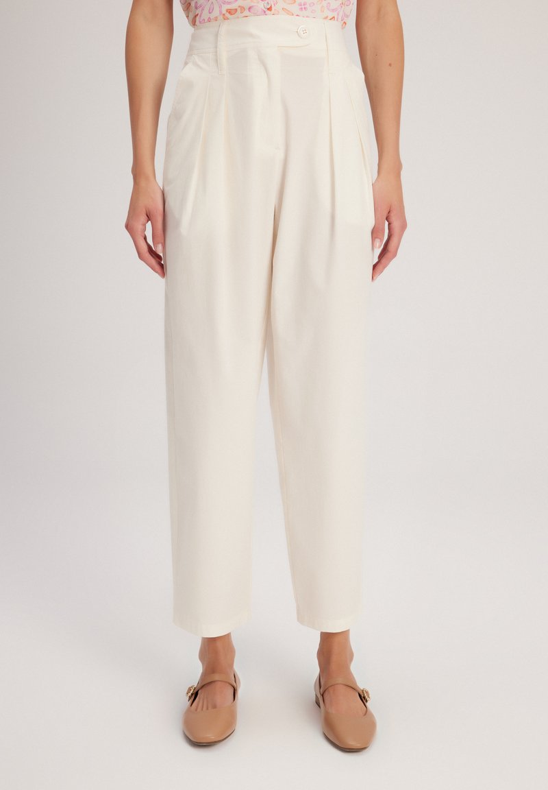 Pantaloni bianchi a vita alta con pieghe, realizzati in tessuto leggero. Presentano una chiusura con bottone frontale e gambe affusolate.