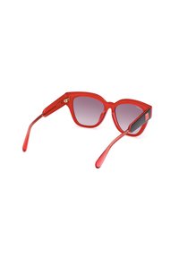 Gafas de sol rojas de gran tamaño con un acabado brillante, lentes con degradado y una forma angular única. Presentan patillas delgadas en rojo con acentos de logo.