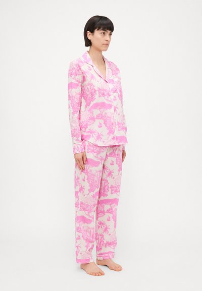 Pink pajama set made of soft fabric, featuring tropical patterns. The top has a collar and buttons, while the pants have a relaxed fit.
