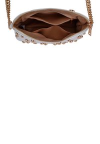 Bolso cruzado blanco con una correa de cadena dorada, adornos de tachuelas doradas, cierre de cremallera y un interior beige con varios compartimentos.