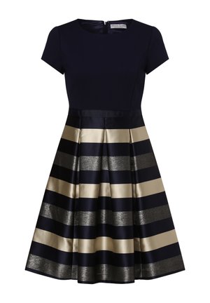 Granatowa dopasowana sukienka z krótkimi rękawami, plisowana spódnica w kształcie litery A z naprzemiennymi kremowymi i metalicznie srebrnymi poziomymi paskami.