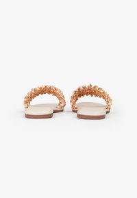 Sandali piatti color tan con una cintura testurizzata e multicolore realizzata con decorazioni floreali e perle, caratterizzati da una suola liscia e una forma rotonda.
