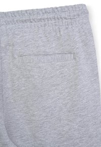 Pantalons de survêtement gris avec une taille élastique, dotés d'une poche à l'arrière, fabriqués en tissu doux et texturé.