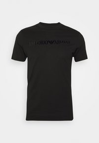 T-shirt nera a maniche corte con collo rotondo, con il logo lucido "Emporio Armani" e l'emblema dell'aquila stampati sul petto.