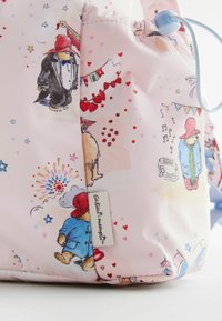 Mėtiniai aksesuarai, siuvami iš šviesiai rožinės medžiagos, puoštos įvairiaspalviais Paddingtono meškiuko piešiniais, širdelėmis, žvaigždėmis ir šventinėmis motyvais.