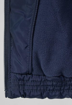 Navy blue jacket featuring a smooth outer layer and soft fleece interior, with elasticated hem and zip closure for secure fit.