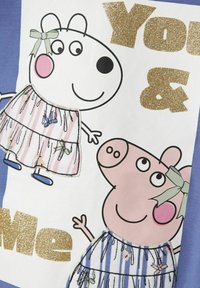 Tela blanca con dos personajes de dibujos animados vestidos; uno es rosa y el otro es blanco con rayas rosas. El texto en purpurina dorada dice "Tú y Yo."