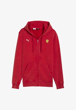 Red zip-up hoodie made of soft fabric. Features a kangaroo pocket, logo patches, ribbed cuffs, and a drawstring hood.