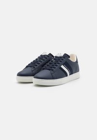 Sneakers sintetici blu navy con accentuazioni bianche, punta rotonda, suola piatta in gomma, lacci texture e logo del marchio sulla linguetta e sul lato.