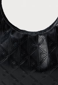 Μαύρη δερμάτινη τσάντα με υφασμάτινο μοτίβο που απεικονίζει επικαλυμμένα διαμάντια και κύκλους. Στρογγυλός ιμάντας ώμου και λεία επιφάνεια.