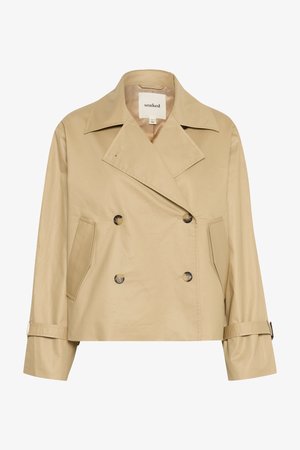 Cappotto doppiopetto beige in un tessuto liscio e leggero. Presenta ampi risvolti, tasche laterali e polsini regolabili. L'etichetta riporta la scritta "inzuppato."