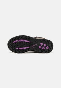 Black sole with purple accents, featuring a textured pattern and traction grips. Made for outdoor use with flexible material for durability.