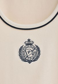 Canotta crema con collo rotondo, caratterizzata da un bordo a coste blu scuro e un logo ricamato in blu navy con un design di corona e alloro.