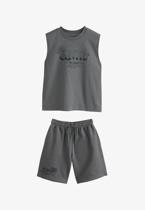 Ærmeløs mørkegrå top med teksten "Unity No Limits" og blomsterdesign, kombineret med matchende elastiske taljeshorts med snøre og lignende tekst.