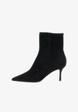 Stivale alla caviglia in suede nero con punta affusolata e sottile tacco stiletto di altezza media, profilo laterale su sfondo bianco.